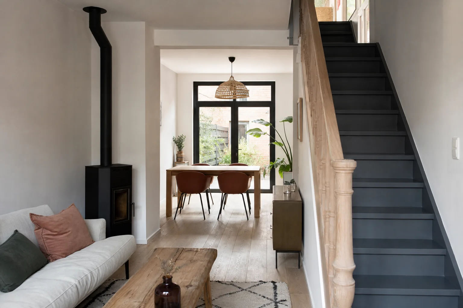 Intérieur rénové d’une maison de coron, séjour traversant clair, poêle installé, escalier bois repeint