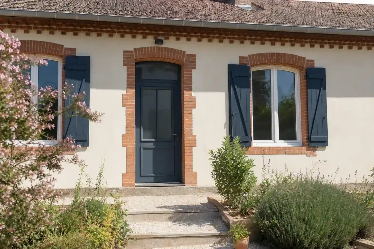 Maison ouvrière de Cagnac-les-Mines rénovée, enduit clair, porte colorée, encadrements de brique conservés