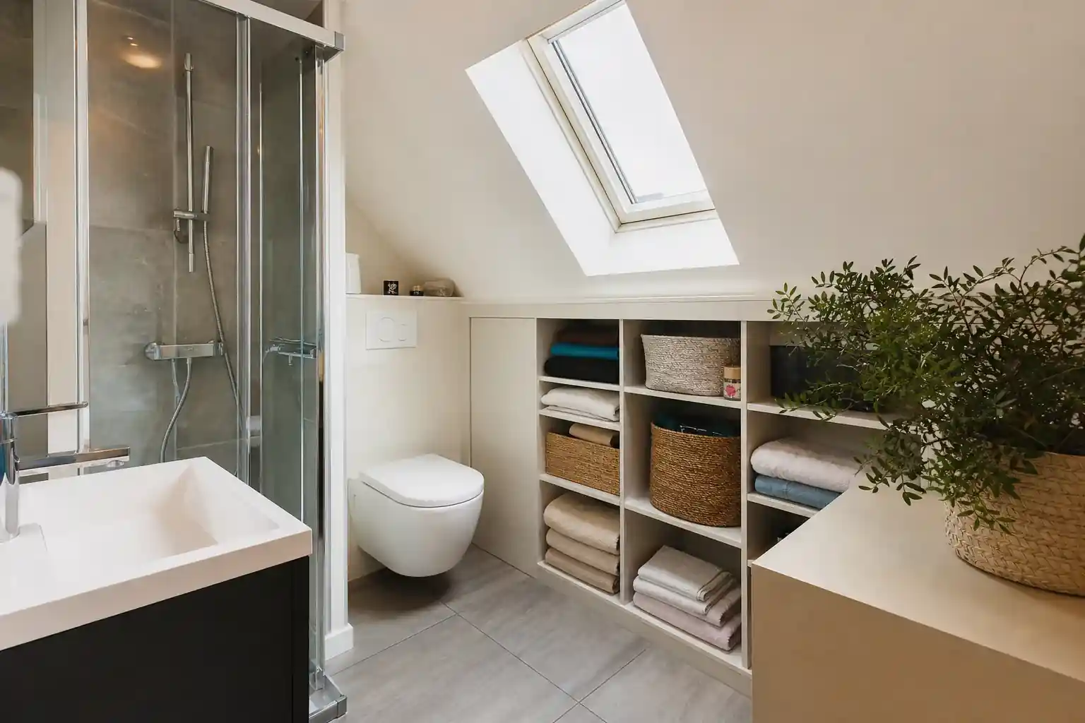 Petite salle d’eau optimisée sous pente dans une maison de ville albigeoise, douche compacte, rangements sur mesure, fenêtre de toit